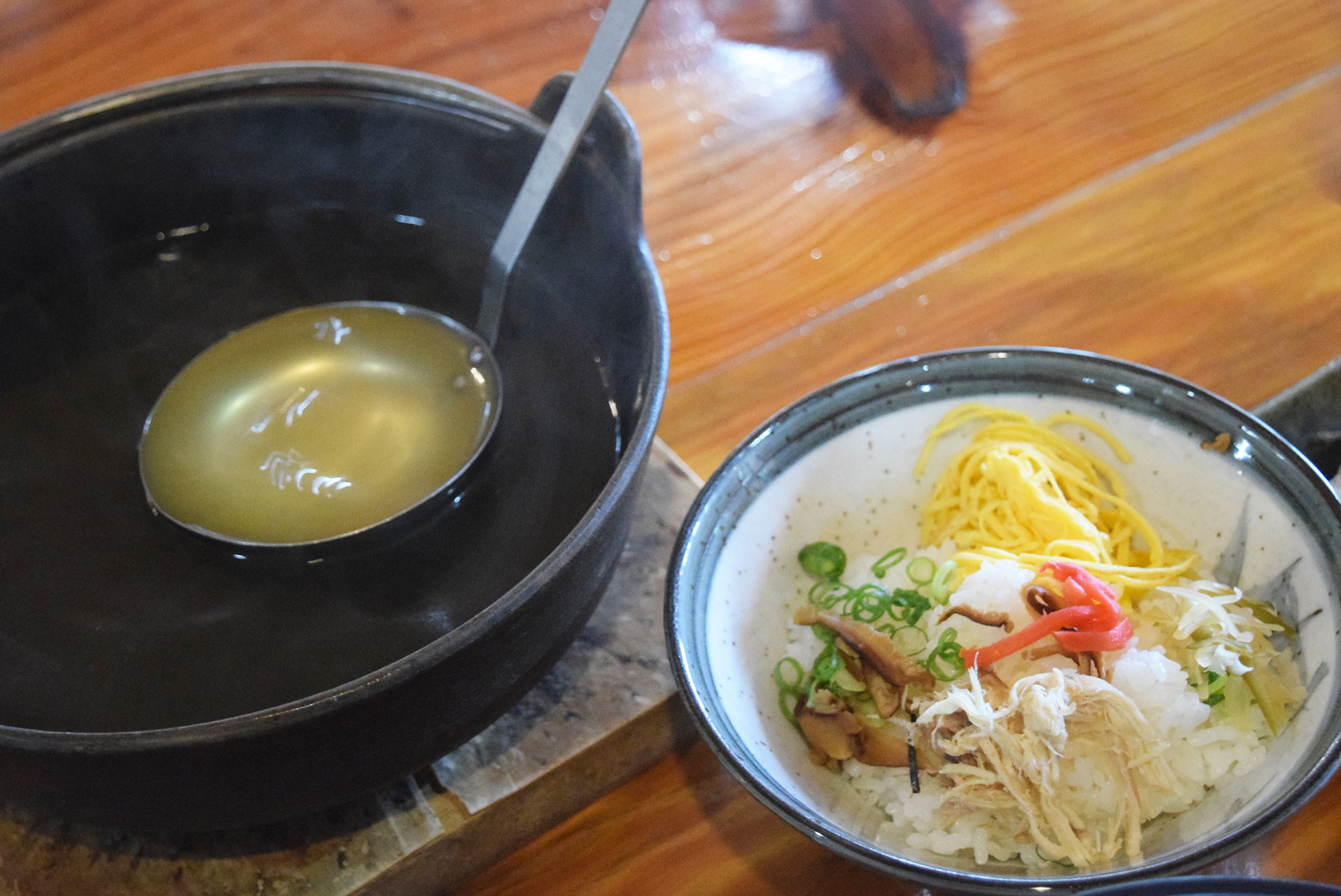 具材を乗せたご飯と、それにかけるスープの写真。