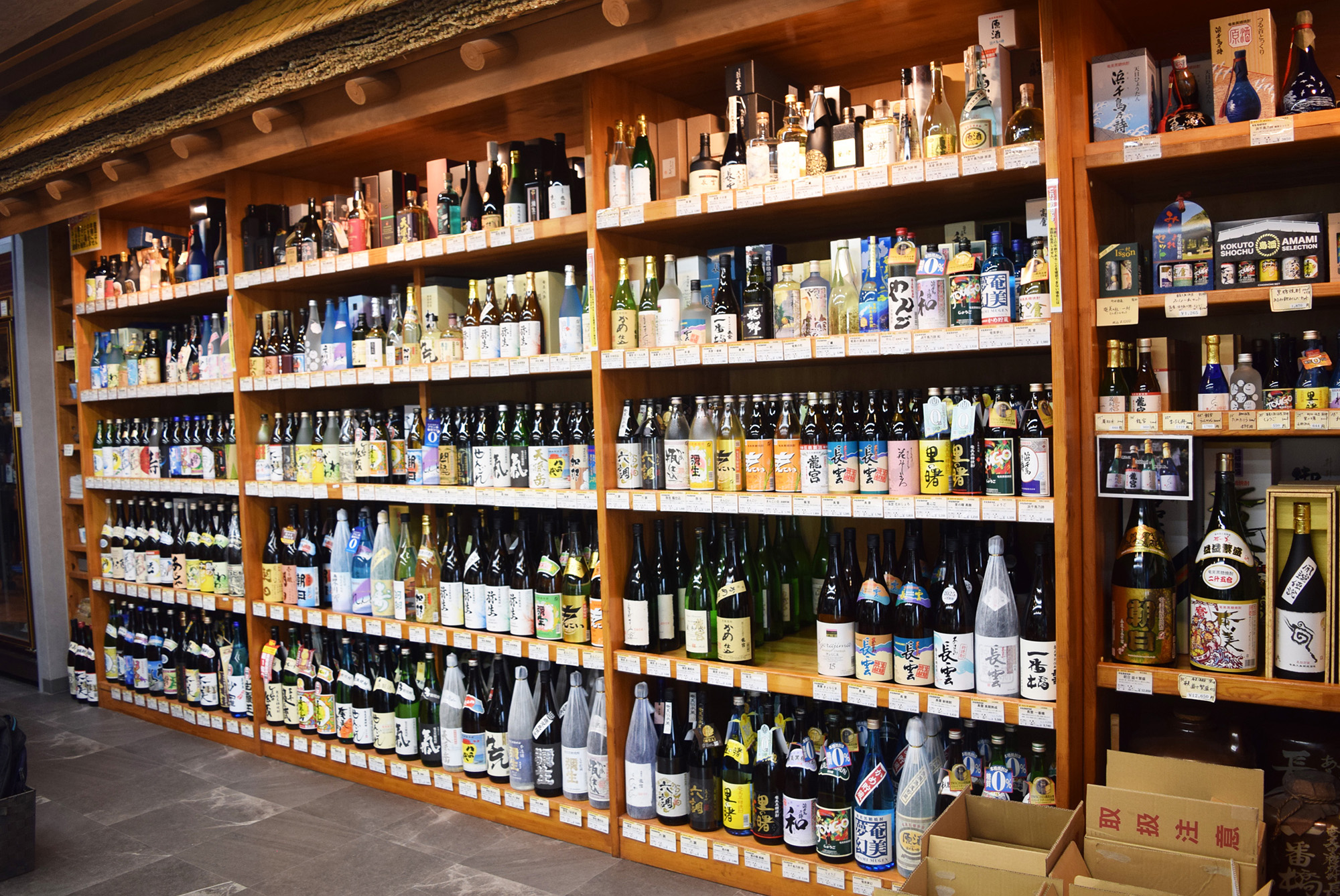 たくさんの焼酎が並ぶ「酒屋まえかわ」の店内写真。