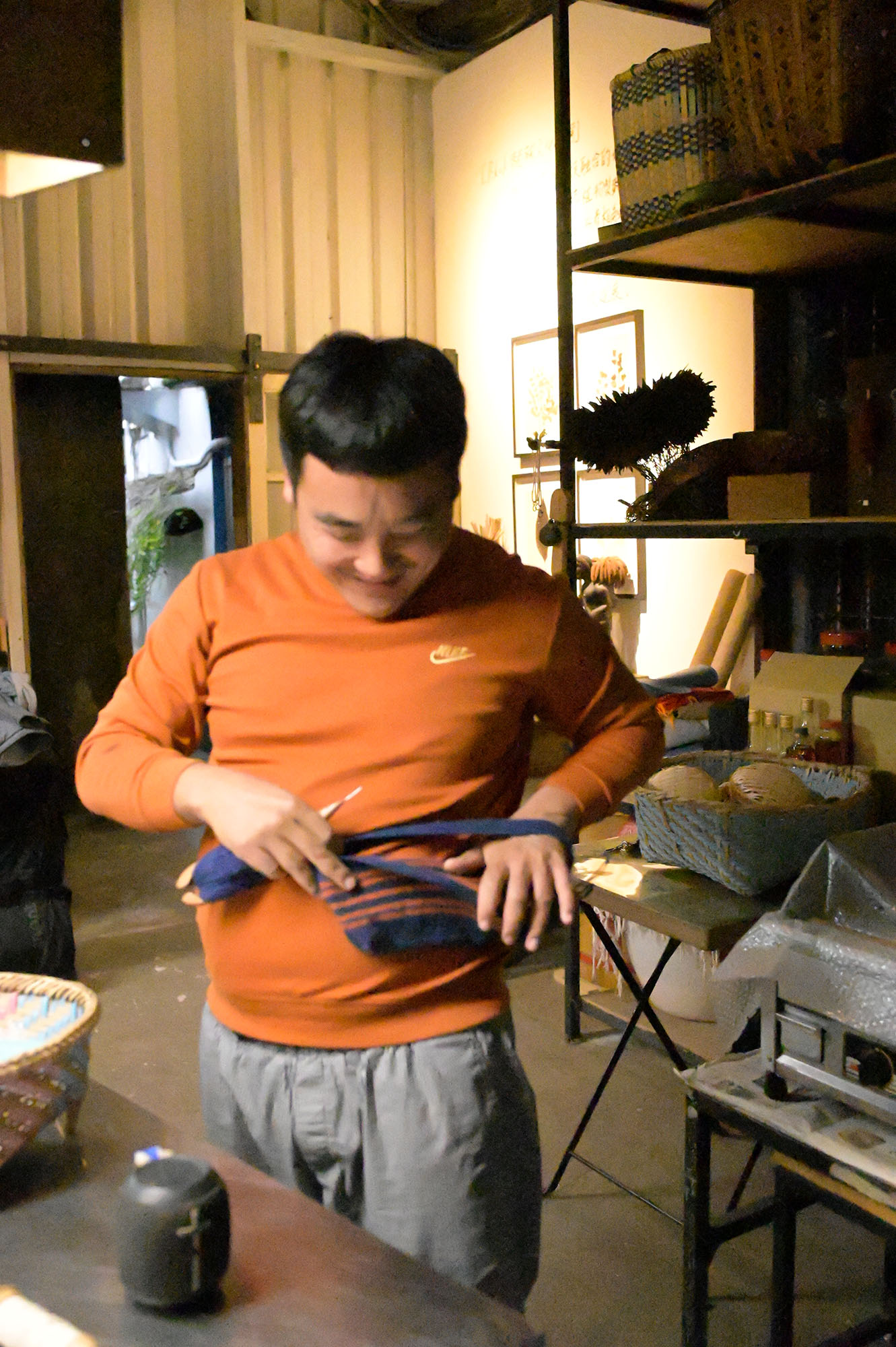 パイワン族の方と、その方が編んでいる編みかけのバッグの写真。